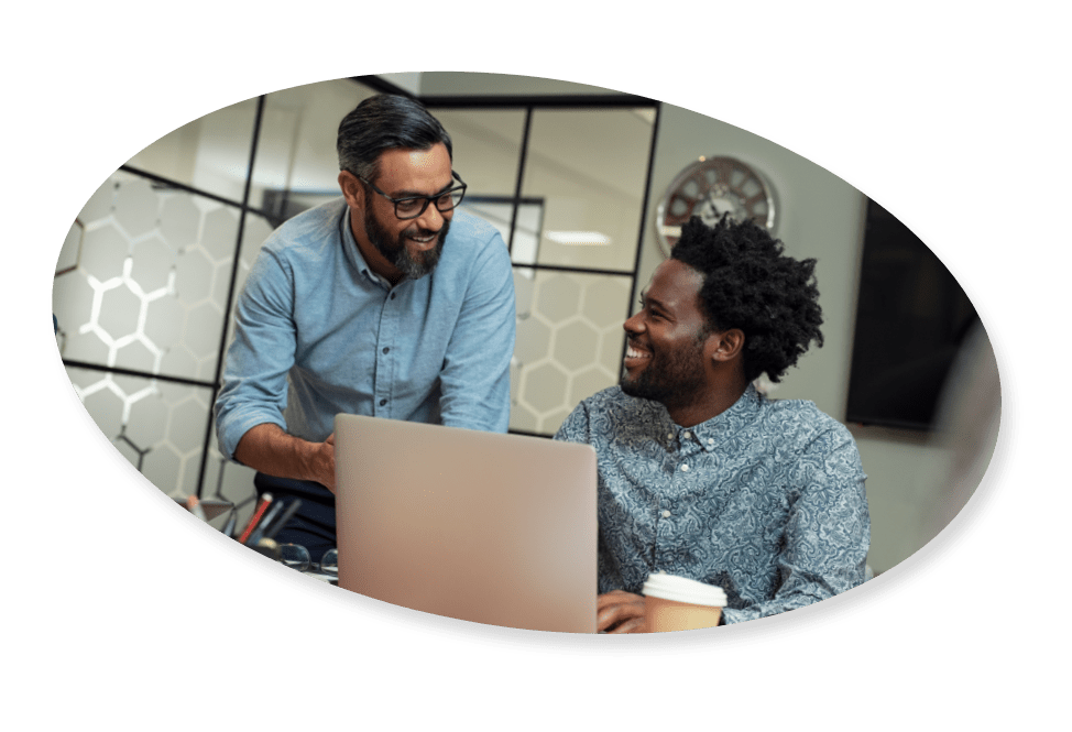 two happy coworkers in a meeting looking at a computer